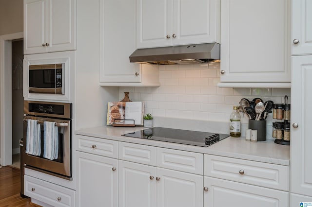 kitchen featuring decorative backsplash, appliances with stainless steel finishes, hardwood / wood-style flooring, and white cabinets