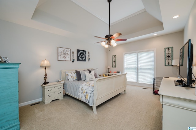 carpeted bedroom with a tray ceiling and ceiling fan