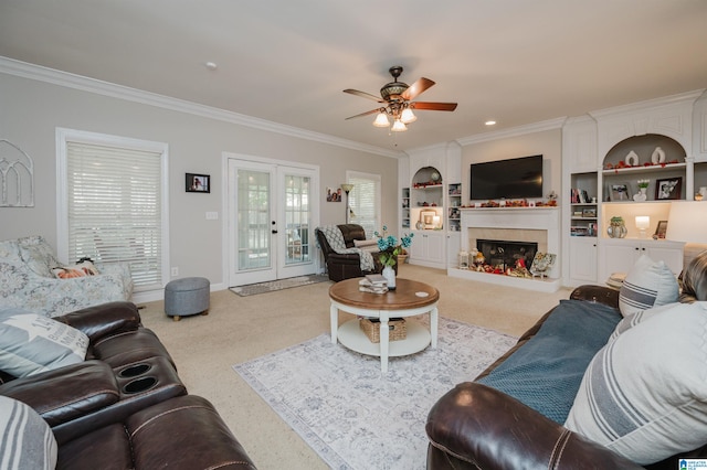 living room with ornamental molding, french doors, built in shelves, and ceiling fan