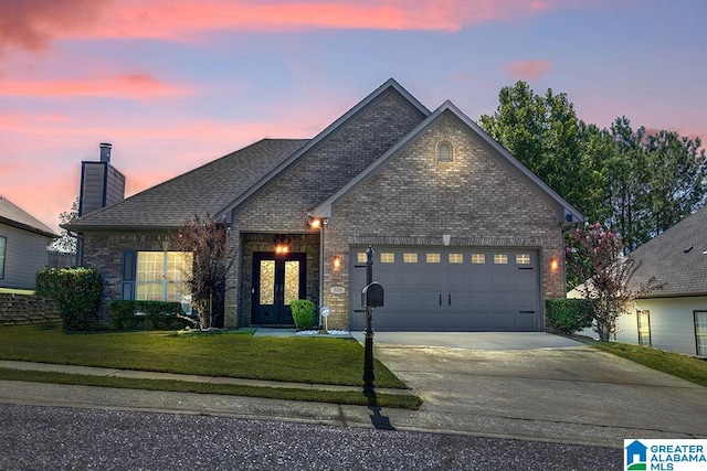 view of front of property with a yard and a garage