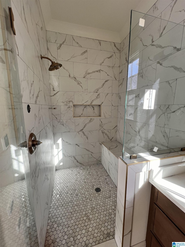 bathroom with tiled shower and vanity