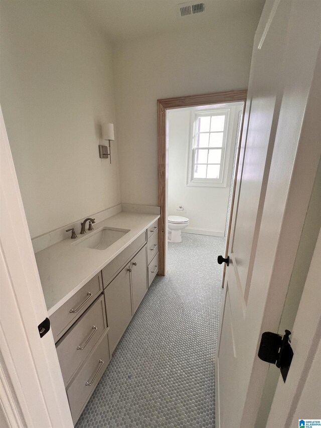 bathroom with tile patterned flooring, vanity, and toilet