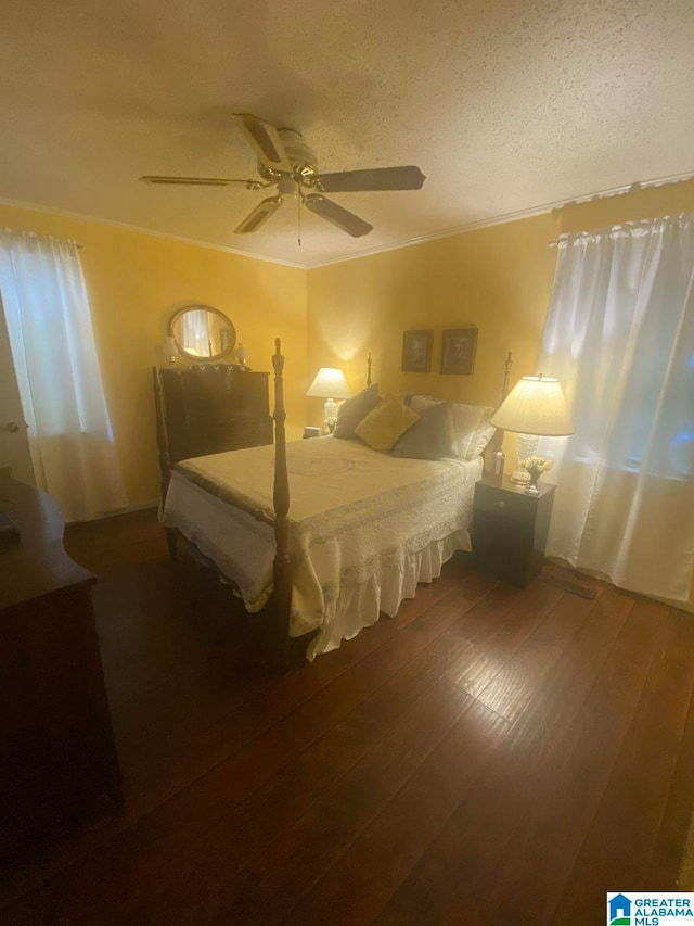 bedroom featuring hardwood / wood-style floors, ceiling fan, and a textured ceiling