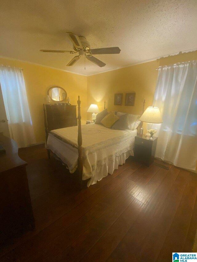 bedroom with a textured ceiling, ceiling fan, and hardwood / wood-style flooring