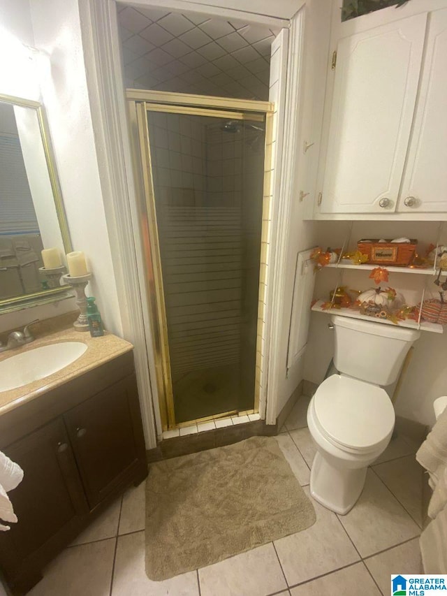 bathroom featuring a shower with door, vanity, toilet, and tile patterned floors