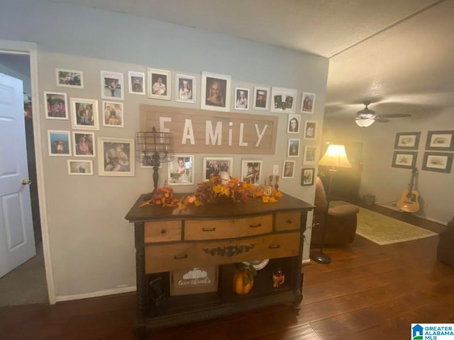 interior space with baseboards, ceiling fan, and wood finished floors