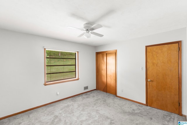 unfurnished bedroom with light colored carpet, ceiling fan, and a closet