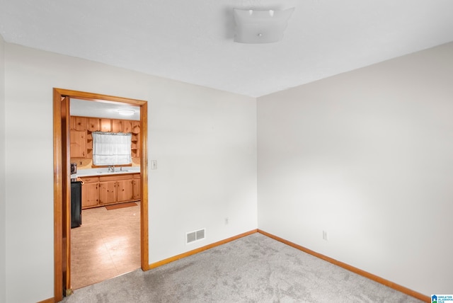 empty room with light carpet and sink