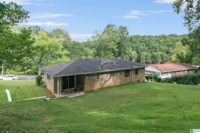 rear view of house with a lawn and a patio area