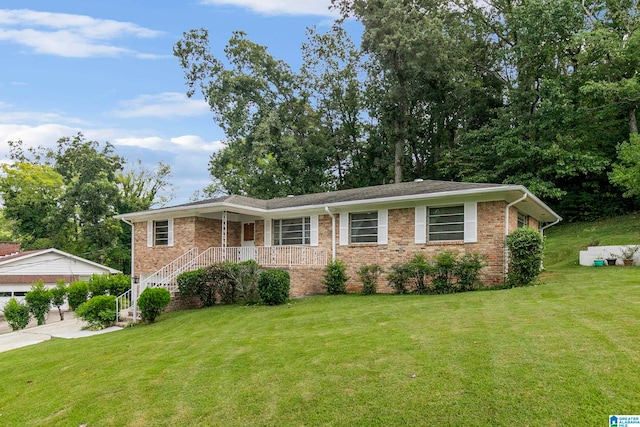 ranch-style home featuring covered porch and a front yard