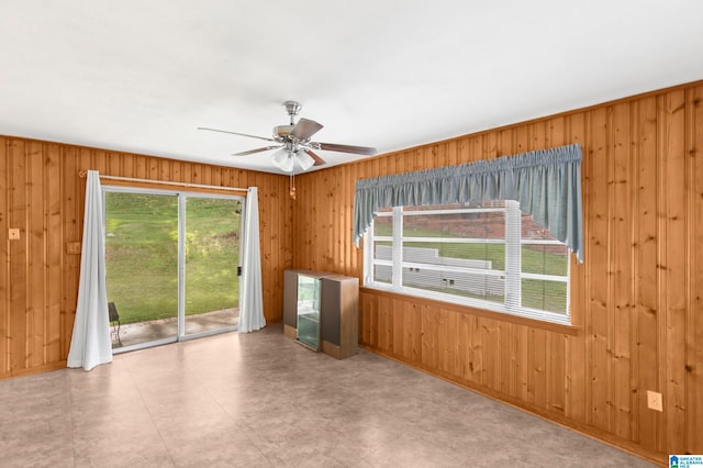 spare room with wood walls and ceiling fan