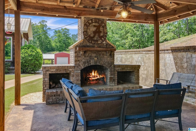 view of patio with ceiling fan, an outdoor brick fireplace, and a gazebo