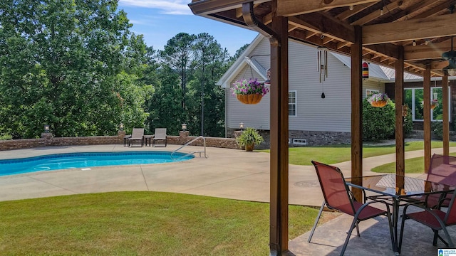 view of pool with a patio area and a yard