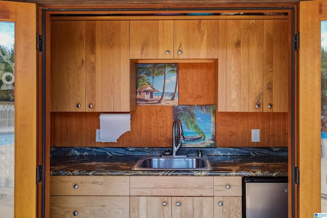 kitchen featuring dark stone countertops and sink