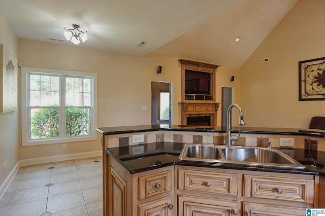 kitchen with light tile patterned floors, sink, and vaulted ceiling