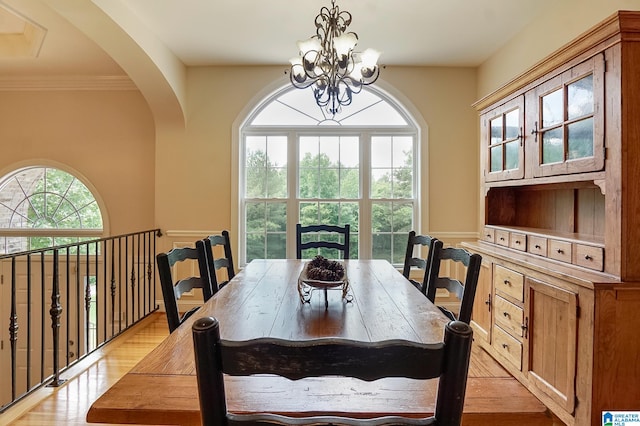 dining space with plenty of natural light, light hardwood / wood-style flooring, and an inviting chandelier