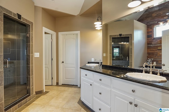 bathroom with tile patterned flooring, a shower with door, and vanity