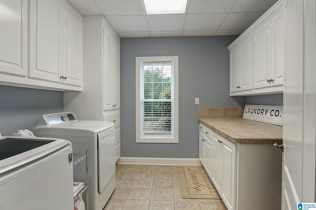 washroom featuring light tile patterned flooring, cabinets, and washer and dryer