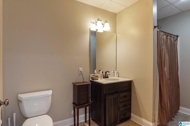 bathroom with a paneled ceiling, toilet, vanity, and a shower with shower curtain