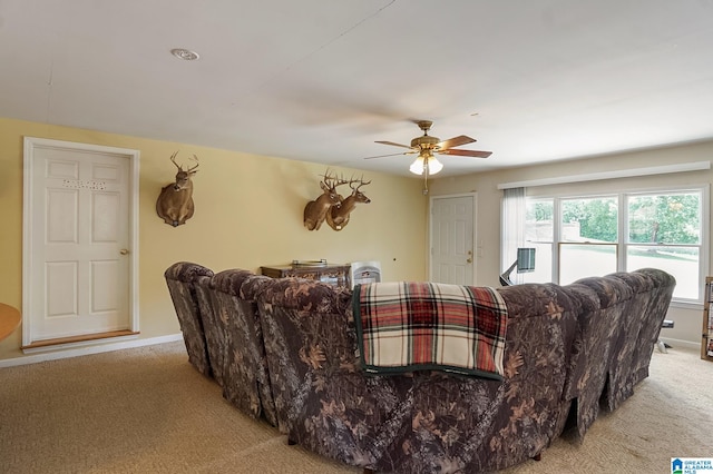 carpeted living room with ceiling fan