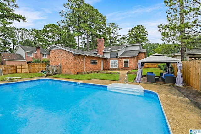 view of swimming pool featuring a gazebo, a lawn, and a fenced in pool