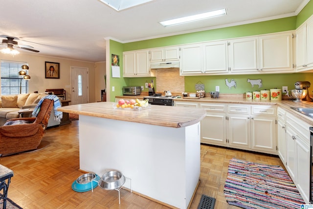 kitchen with ceiling fan, white cabinets, a skylight, and plenty of natural light