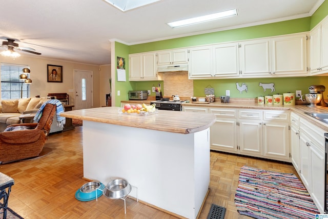 kitchen with open floor plan, crown molding, light countertops, and white cabinets