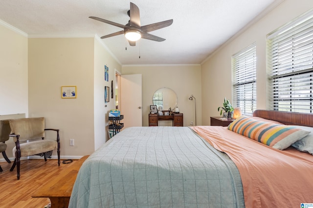 bedroom featuring wood-type flooring, ornamental molding, and ceiling fan