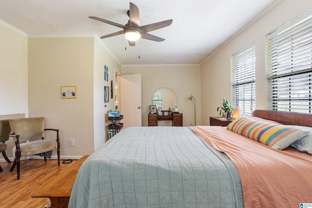 bedroom featuring multiple windows, ornamental molding, and wood finished floors