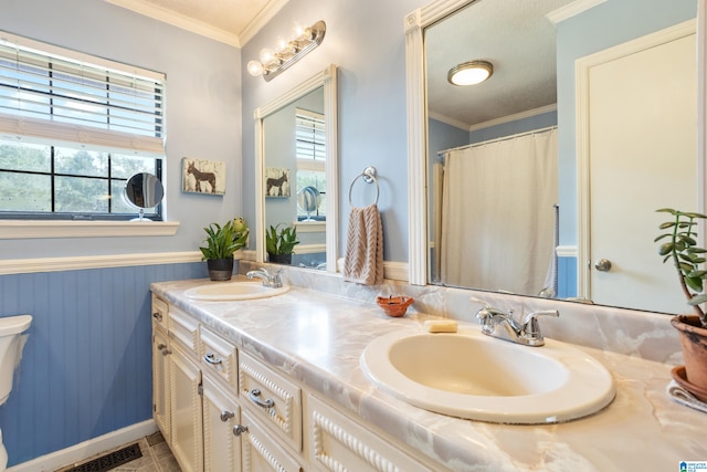 bathroom with vanity, crown molding, and toilet