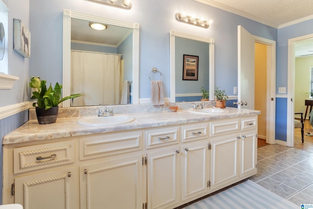 bathroom with ornamental molding, a textured ceiling, and vanity