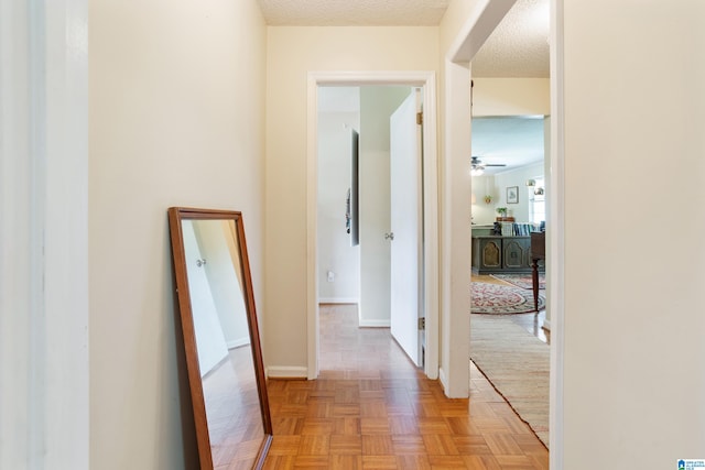 hall with a textured ceiling and light parquet flooring