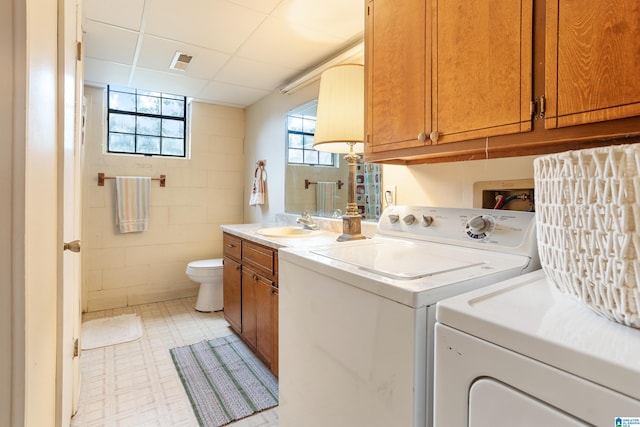 laundry area with visible vents, a sink, laundry area, independent washer and dryer, and light floors