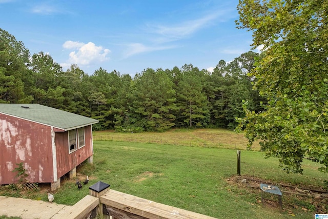 view of yard with a wooded view and an outdoor structure
