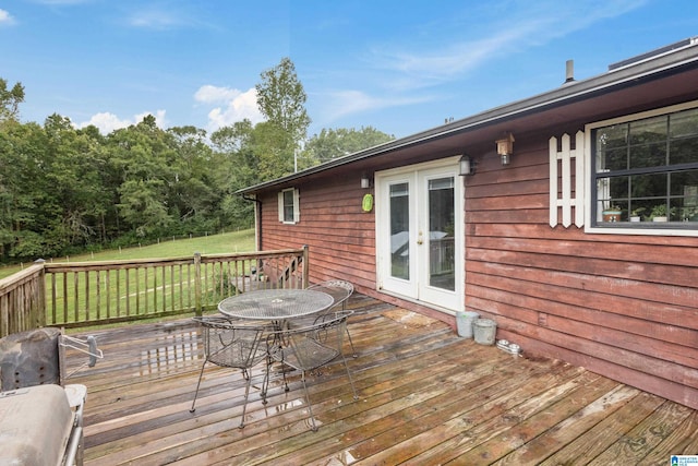 wooden terrace featuring french doors and a yard