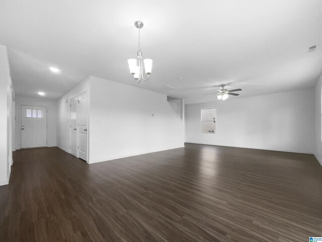 spare room featuring ceiling fan with notable chandelier and dark hardwood / wood-style flooring