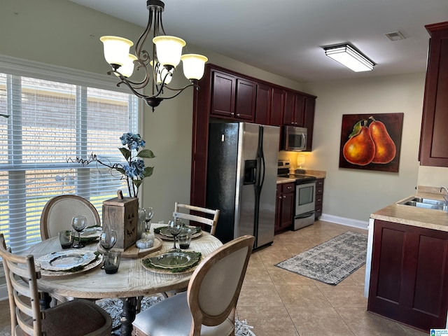 dining area with an inviting chandelier, sink, and light tile patterned floors