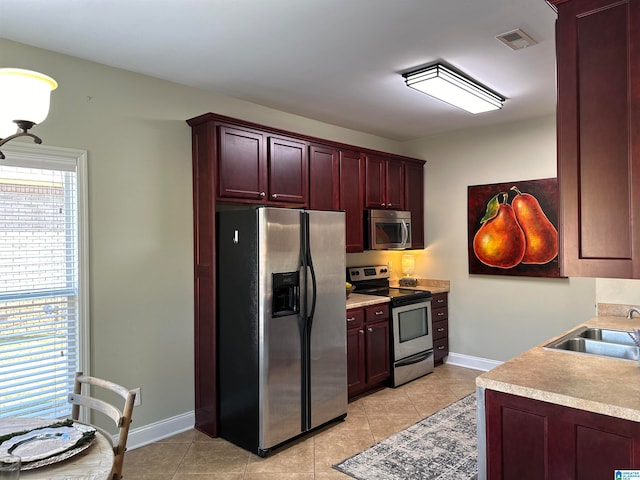 kitchen with light tile patterned floors, appliances with stainless steel finishes, and sink