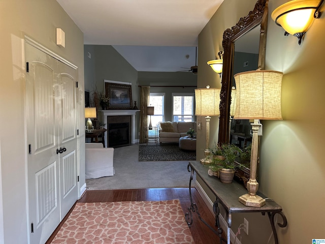 hallway featuring vaulted ceiling and hardwood / wood-style flooring