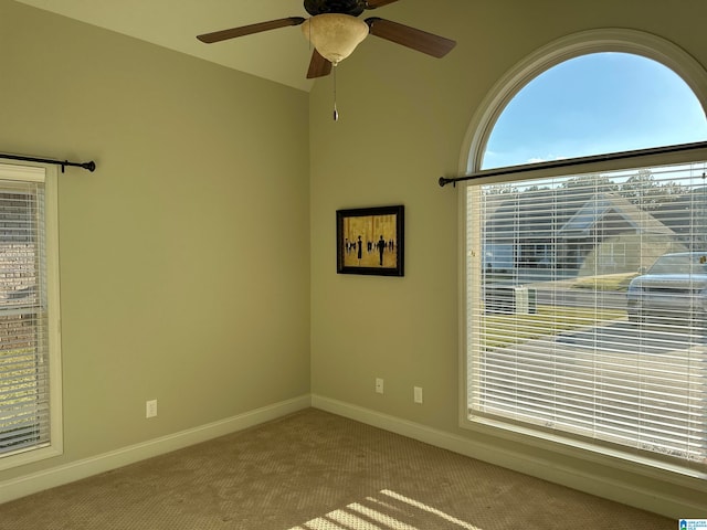 carpeted spare room with ceiling fan