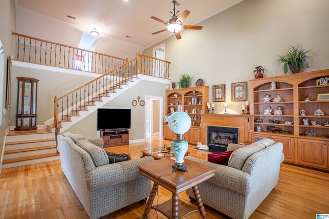 living room with high vaulted ceiling, light hardwood / wood-style flooring, and ceiling fan