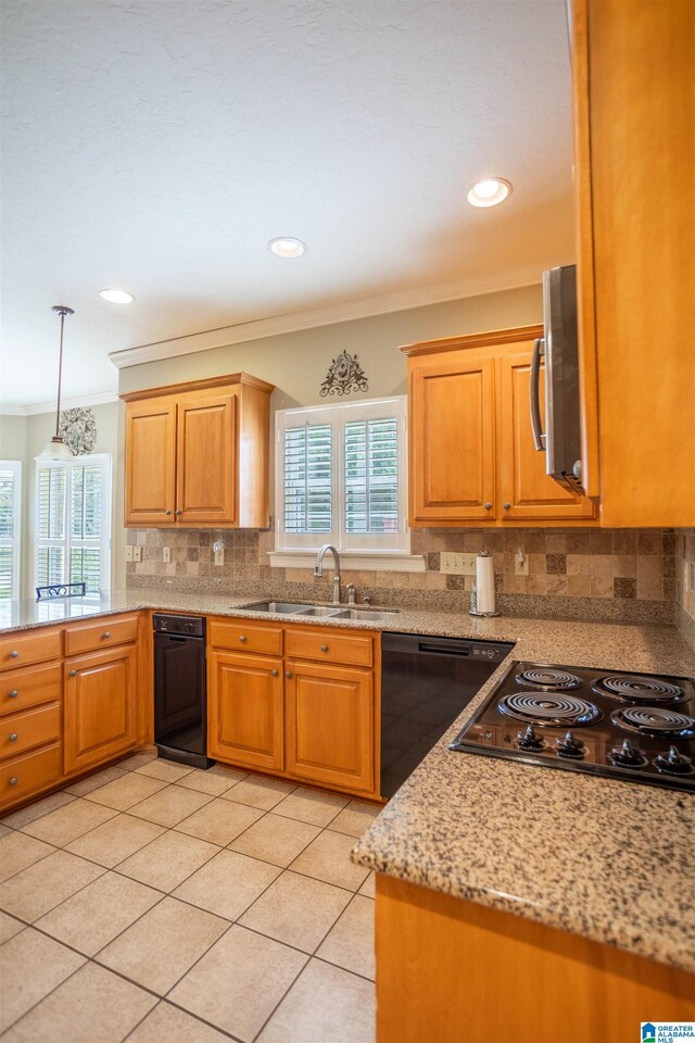 kitchen with hanging light fixtures, crown molding, light stone countertops, sink, and black appliances