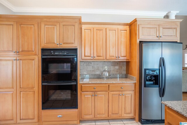 kitchen featuring light tile patterned floors, crown molding, light stone countertops, stainless steel fridge, and double oven