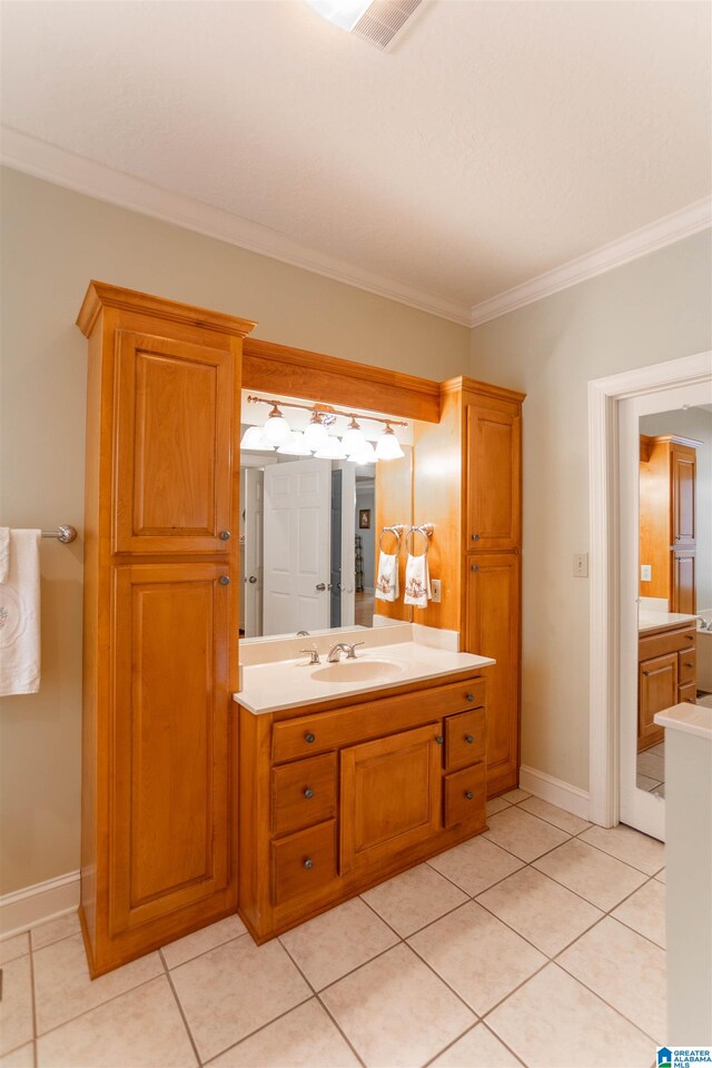 bathroom with crown molding, vanity, and tile patterned flooring