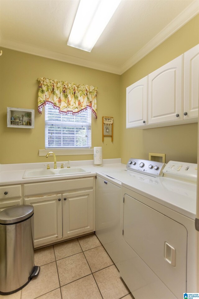 laundry area with cabinets, separate washer and dryer, light tile patterned floors, crown molding, and sink