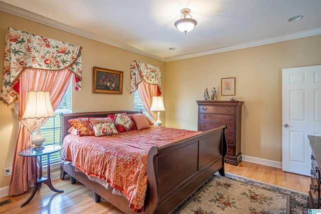 bedroom with light hardwood / wood-style floors and crown molding