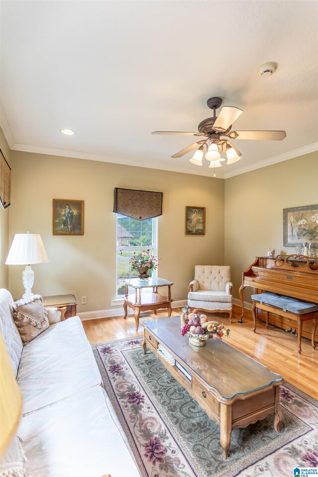 living room featuring crown molding, ceiling fan, and light hardwood / wood-style floors