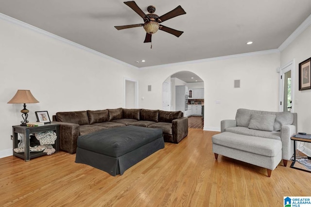 living room featuring crown molding, light hardwood / wood-style flooring, and ceiling fan