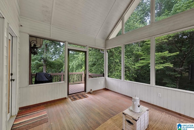 unfurnished sunroom featuring lofted ceiling and plenty of natural light