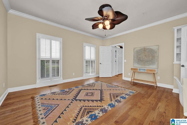 entryway with ceiling fan, crown molding, and wood-type flooring